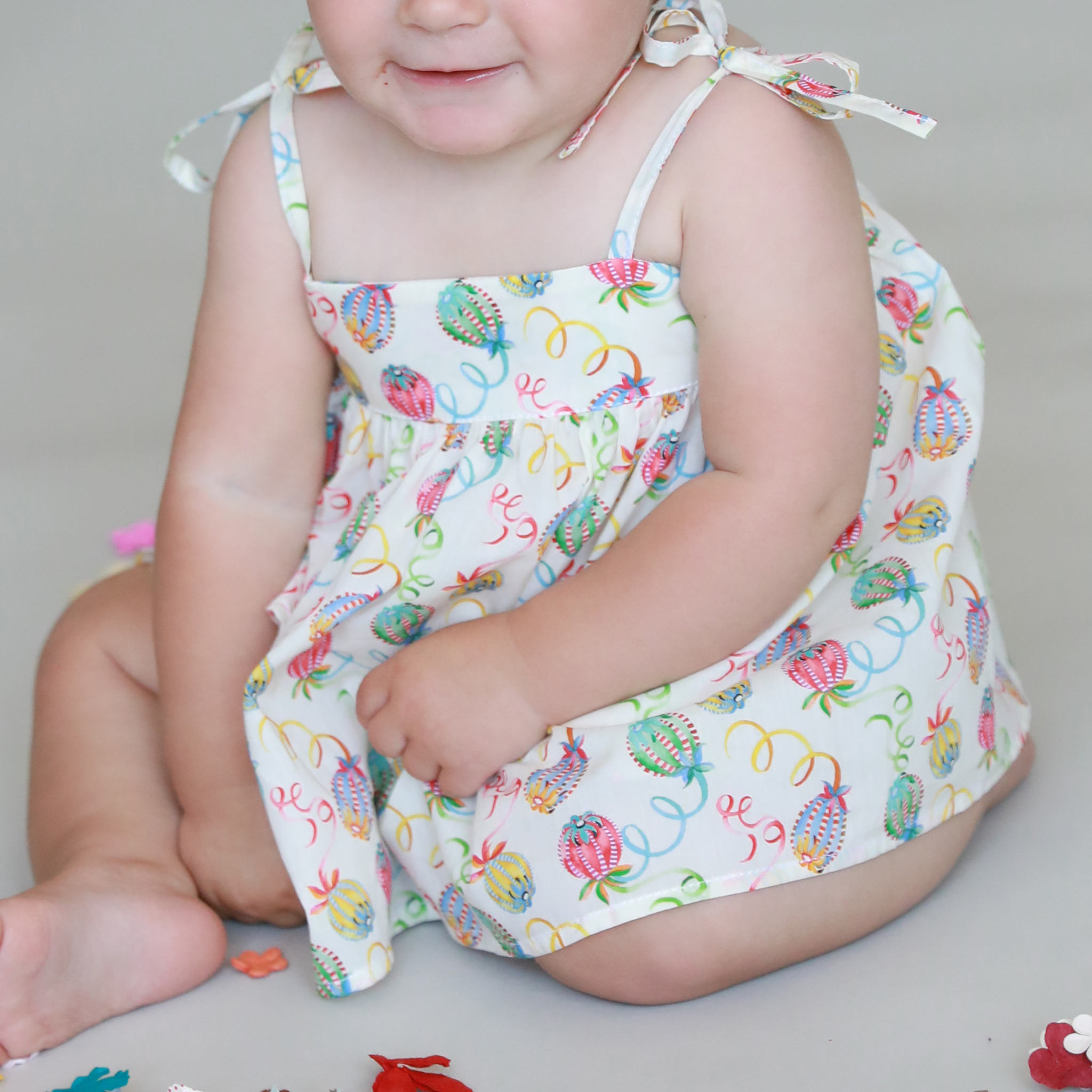 Child wearing a colorful blouse on a neutral background